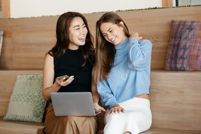 To kvinder griner med computer